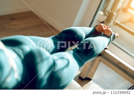 Unrecognizable girl enjoying Pilates taking care of her body and mind training legs Unrecognizable girl enjoying Pilates taking care of her body and mind training legs 112299092