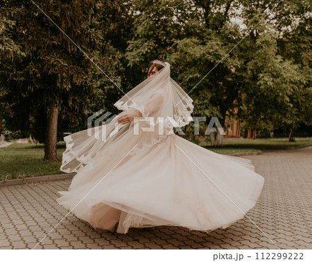 Caucasian young woman bride spinning whirls dancing posing moving at nature 112299222