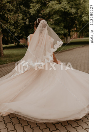 Caucasian young woman bride spinning whirls dancing posing moving at nature Caucasian young woman bride spinning whirls dancing posing moving at nature 112299227