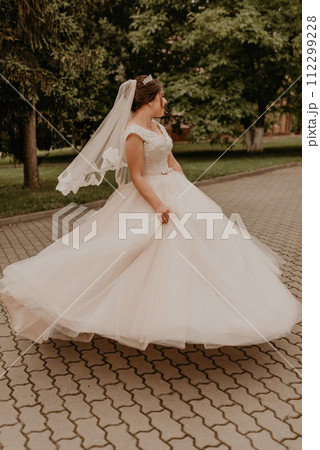 Caucasian young woman bride spinning whirls dancing posing moving at nature 112299228