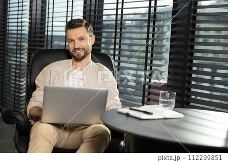 Young bearded man in casual clothes working on laptop 112299851