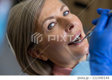 Woman sitting in dental chair teeth treatment Woman sitting in dental chair teeth treatment 112300148