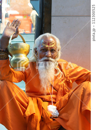 Ascetic monk Sadhu in India with beard, white hair and painted face preaching 112300525