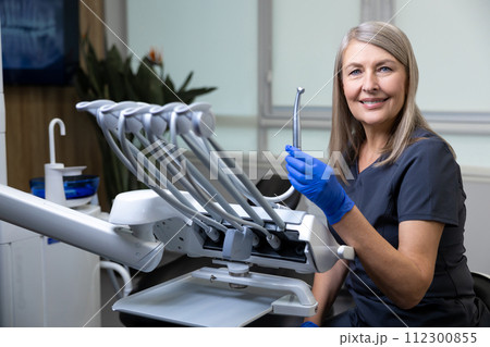 Female dentist wearing uniform sitting in her doctors room 112300855