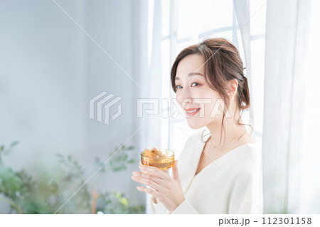 窓辺でお茶を飲む女性 112301158
