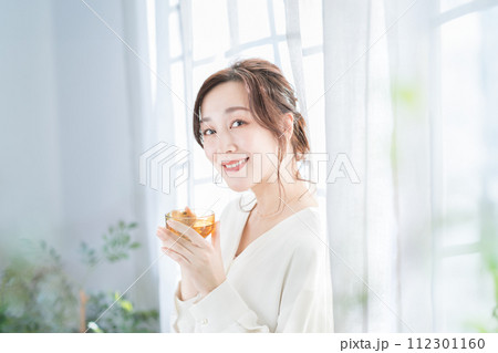 窓辺でお茶を飲む女性 112301160