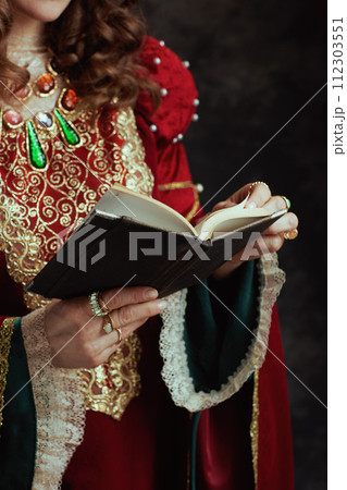 Closeup on medieval queen in red dress with book Closeup on medieval queen in red dress with book 112303551