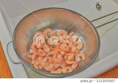 Cooked and peeled prawns in strainer. Food photography. Healthy food 112305087