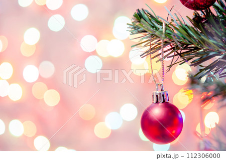 Christmas decoration. Red balls hanging on pine branches Christmas tree garland and ornaments over abstract bokeh background with copy space Christmas decoration. Red balls hanging on pine branches Christmas tree garland and ornaments over abstract bokeh background with copy space 112306000