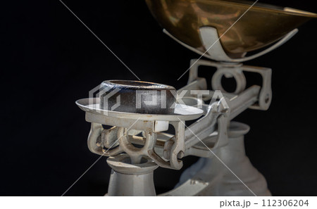 Cast iron weights on Old obsolete manual weighing scales and Iron Brass Tray on dark background. Cast iron weights on Old obsolete manual weighing scales and Iron Brass Tray on dark background. 112306204
