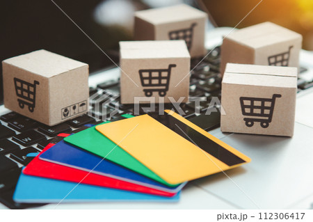 Shopping online. Credit card and cardboard box with a shopping cart logo on laptop keyboard. Shopping service on The online web. offers home delivery 112306417