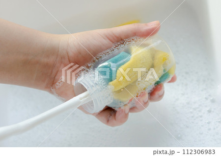 Washing baby bottle. Mother's hand washing the baby bottle.. Washing baby bottle. Mother's hand washing the baby bottle.. 112306983