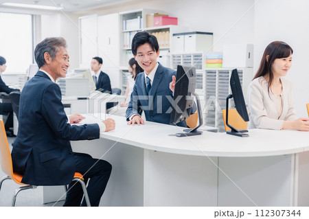 窓口でお客様の対応をするビジネスウーマン 112307344