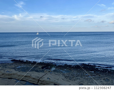 View of the sea and white sailboat on the horizon from the balcony on the promenade by the sea at Sliema  Malta 112308247