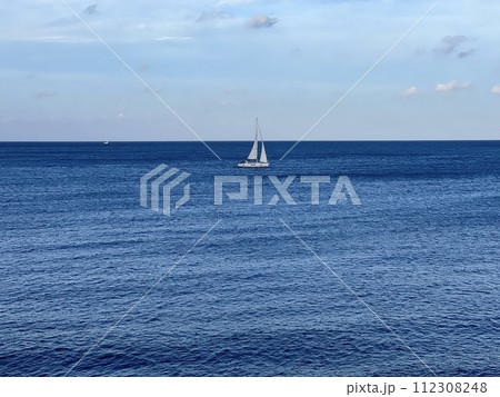 View of the sea and white sailboat on the horizon from the balcony on the promenade by the sea at Sliema Malta View of the sea and white sailboat on the horizon from the balcony on the promenade by the sea at Sliema Malta 112308248
