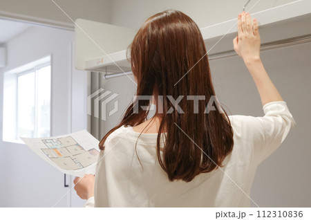 ウォークインクローゼットの内見をする女性 112310836