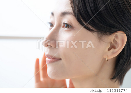 窓からの日差しを受ける女性 112311774