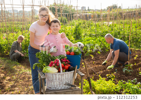 Girl and boy posing in garden with harvest 112312253