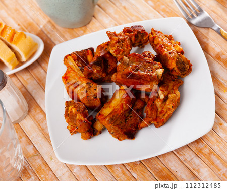 Appetizing delicious fried pork ribs on plate. Nutritious lunch Appetizing delicious fried pork ribs on plate. Nutritious lunch 112312485