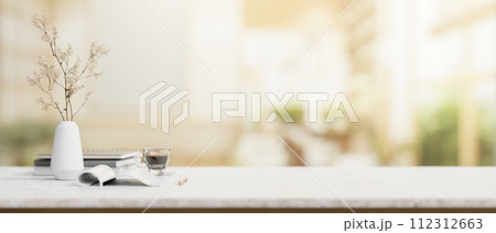 A white marble table features a copy space with a blurred background of a modern bright room. A white marble table features a copy space with a blurred background of a modern bright room. 112312663