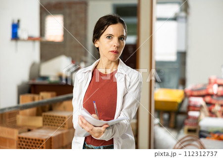 Motivated woman making notes on home space planning during renovation 112312737