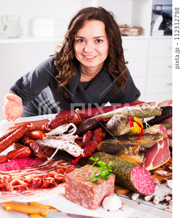 Woman stands with smoked products 112312798