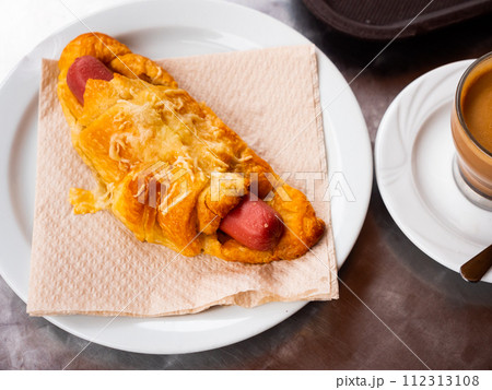 Croissant with sausage served with coffee Croissant with sausage served with coffee 112313108