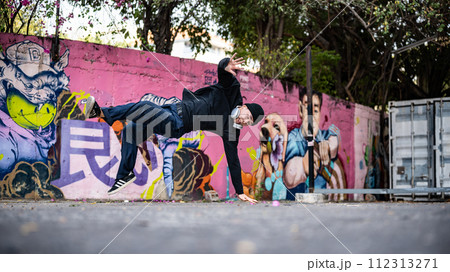 A talented and energetic Asian male breakdancer is dancing hiphop b-boy outdoors. A talented and energetic Asian male breakdancer is dancing hiphop b-boy outdoors. 112313271