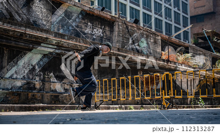A cool, hipster Asian man is enjoying with the rhythm and dancing hiphop on the street. A cool, hipster Asian man is enjoying with the rhythm and dancing hiphop on the street. 112313287
