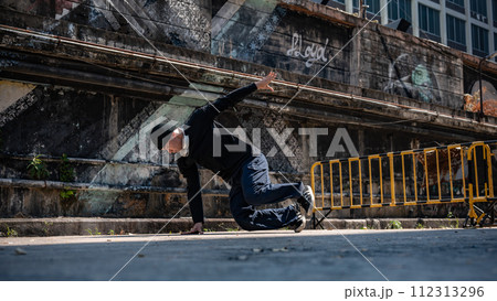 A cool Asian hiphop dancer is dancing on the street, breakdancing, showcasing his talented movements A cool Asian hiphop dancer is dancing on the street, breakdancing, showcasing his talented movements 112313296