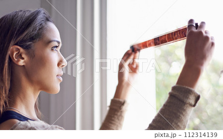 Woman, photographer and filmstrip negative for creative prints at window for retro images for portfolio, inspiration or hobby. Female person, artistic and roll for picture, development or photoshoot Woman, photographer and filmstrip negative for creative prints at window for retro images for portfolio, inspiration or hobby. Female person, artistic and roll for picture, development or photoshoot 112314139
