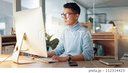 Asian man at computer, glasses and ideas, thinking and reading email, web review or article at digital agency. Research, reflection and businessman at tech startup networking on business website. 112314423