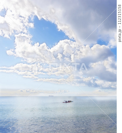 Ocean, blue sky and people on kayak for adventure, sports and travel on natural background or landscape. Sea, fresh air and clouds with calm water, boat on journey and recreation activity for holiday 112315158