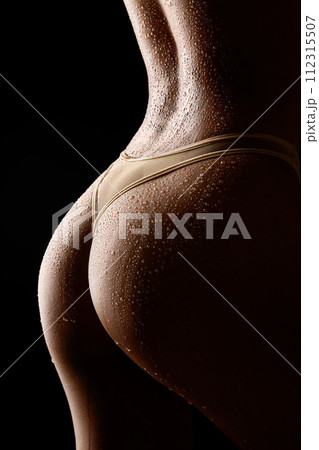Close-up of an wet female back with water drops on a black background 112315507