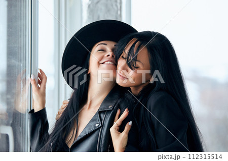 2 Beautiful sexy women posing against the window in black jackets 2 Beautiful sexy women posing against the window in black jackets 112315514