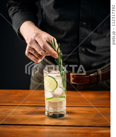 Man making fresh gin tonic cocktail with lime 112317392