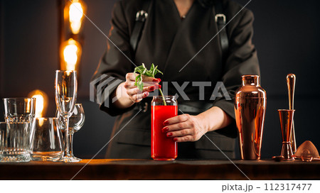 Woman making bloody mary cocktail with celery Woman making bloody mary cocktail with celery 112317477