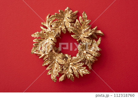 赤い背景に置かれた金色のクリスマスリース 赤い背景に置かれた金色のクリスマスリース 112318760