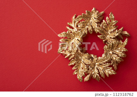 赤い背景に置かれた金色のクリスマスリース 赤い背景に置かれた金色のクリスマスリース 112318762