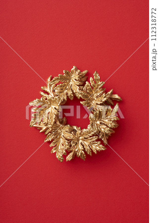 赤い背景に置かれた金色のクリスマスリース 赤い背景に置かれた金色のクリスマスリース 112318772
