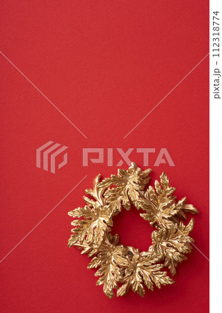赤い背景に置かれた金色のクリスマスリース 赤い背景に置かれた金色のクリスマスリース 112318774