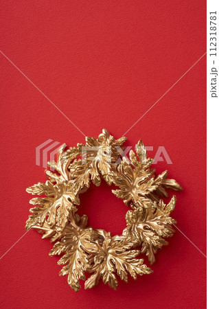 赤い背景に置かれた金色のクリスマスリース 赤い背景に置かれた金色のクリスマスリース 112318781
