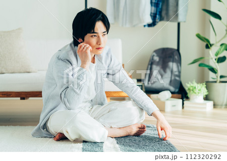 リビングでくつろぐ若い男性 112320292