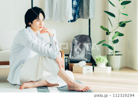 リビングでくつろぐ若い男性 リビングでくつろぐ若い男性 112320294