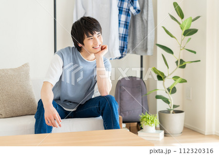 リビングでくつろぐ若い男性 リビングでくつろぐ若い男性 112320316