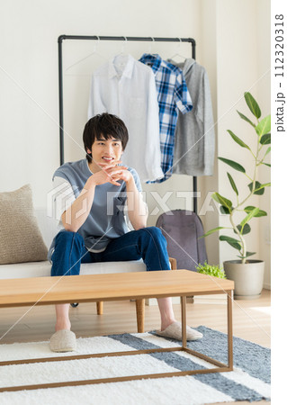 リビングでくつろぐ若い男性 リビングでくつろぐ若い男性 112320318