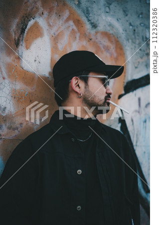 ストリートアートの前でタバコを吸う男性 ストリートアートの前でタバコを吸う男性 112320386