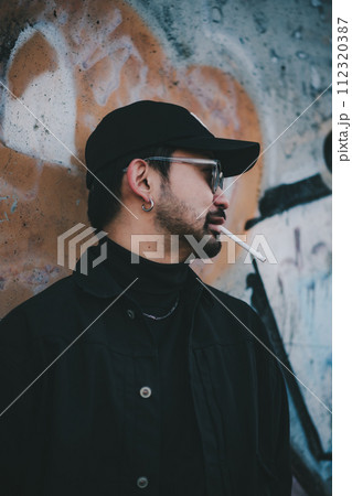 ストリートアートの前でタバコを吸う男性 ストリートアートの前でタバコを吸う男性 112320387