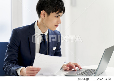 書類の内容を調べるビジネスマン 112321318
