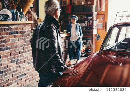 愛車を見ながら会話をしているシニア夫婦の写真 愛車を見ながら会話をしているシニア夫婦の写真 112322023
